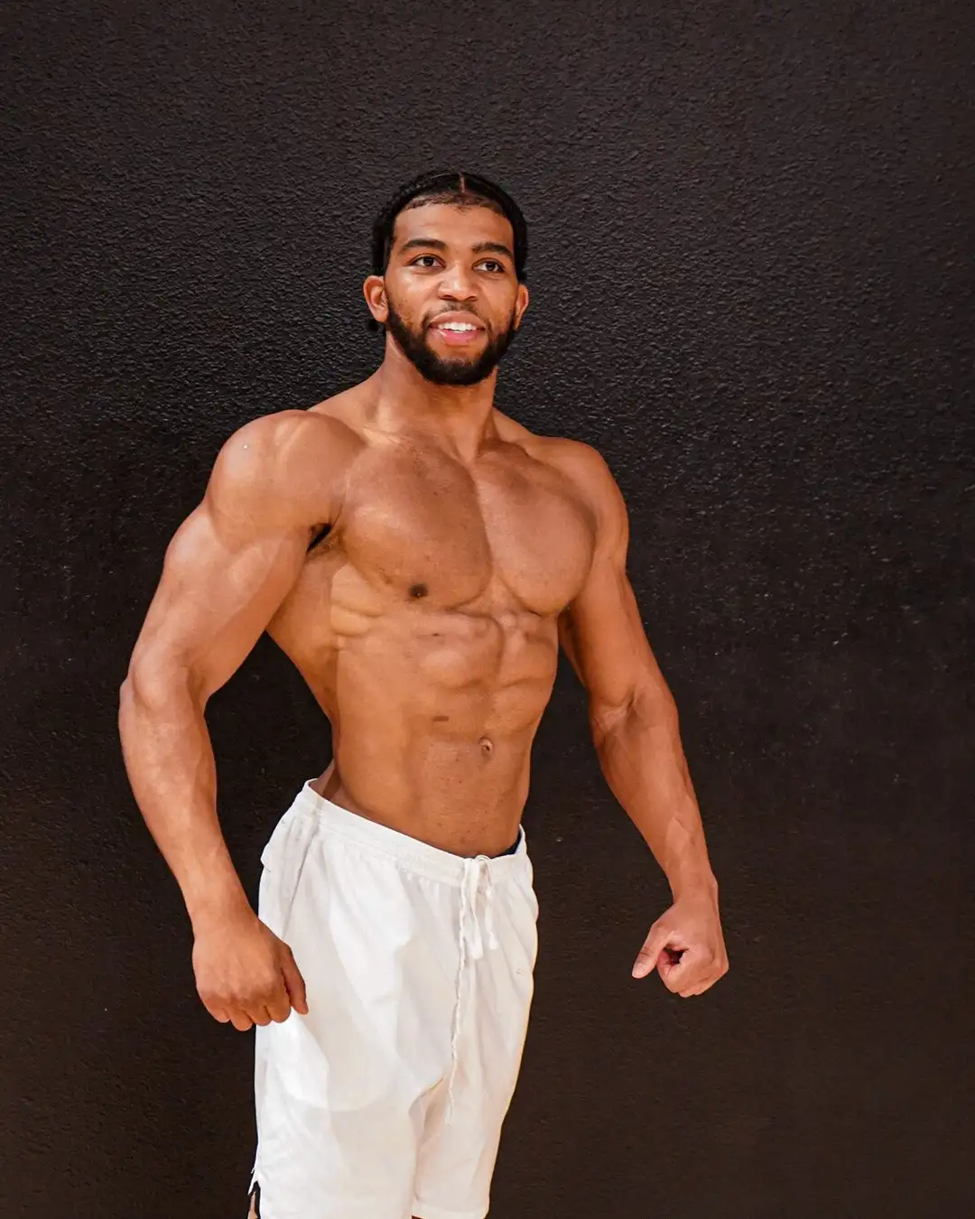 Branden, black-wall physique portrait, standing, shorts